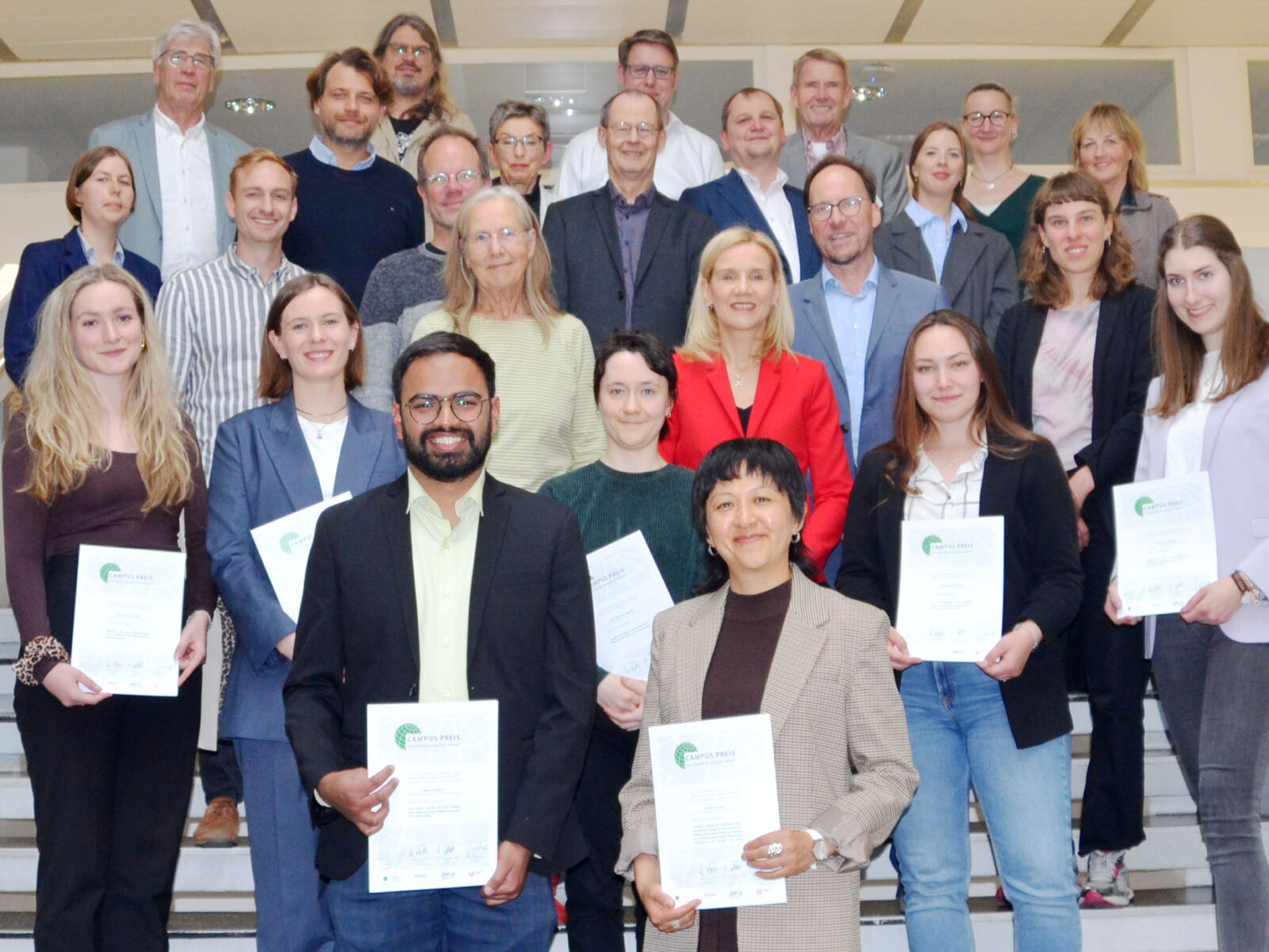 Gruppenbild mit Preisträger*innen und weiteren Beteiligten auf einer Treppe