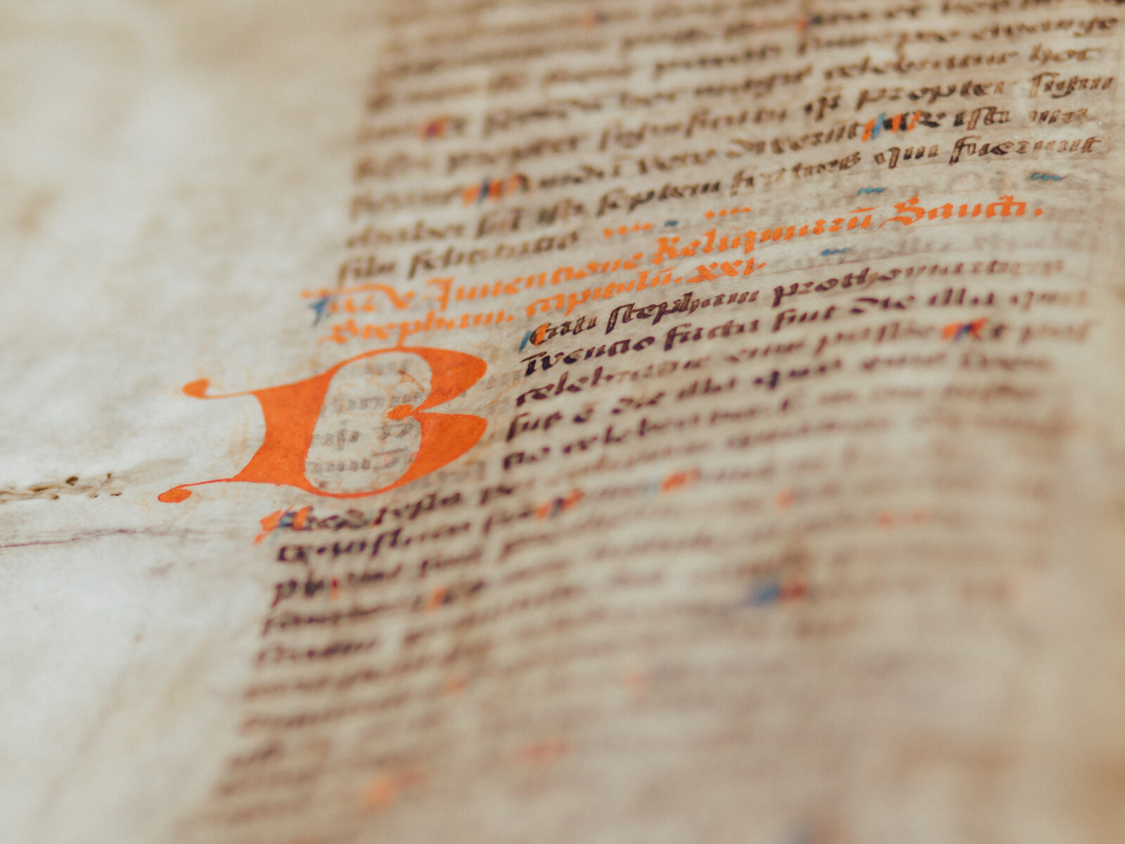 Das Bild zeigt einen Ausschnitt aus einem alten, handgeschriebenen Buch. Ein kunstvoll verzierter Buchstabe leitet den Text ein, der dicht und in altertümlicher Schrift geschrieben ist. Es vermittelt den Eindruck von Geschichte und gelehrter Arbeit.