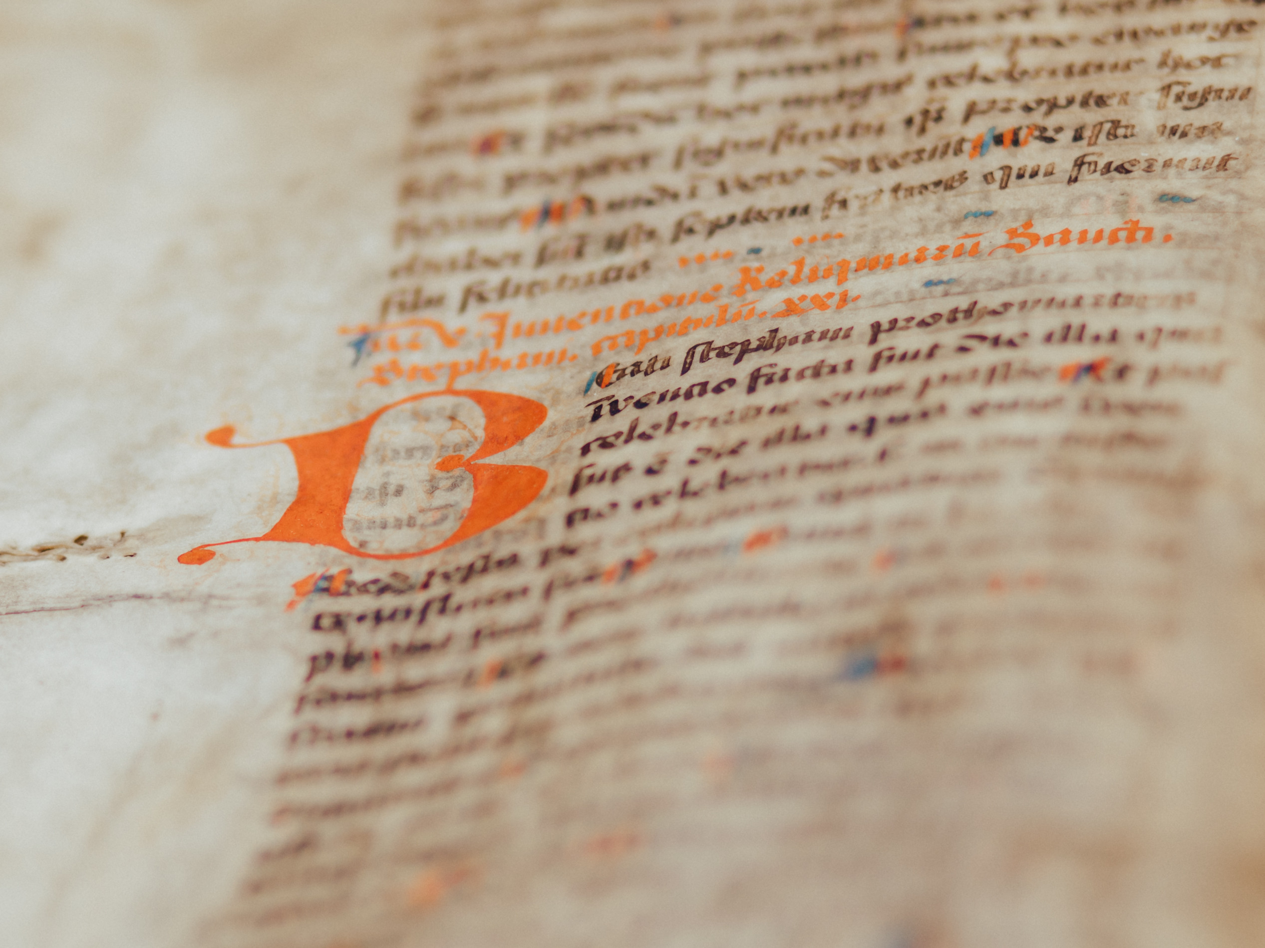 Das Bild zeigt einen Ausschnitt aus einem alten, handgeschriebenen Buch. Ein kunstvoll verzierter Buchstabe leitet den Text ein, der dicht und in altertümlicher Schrift geschrieben ist. Es vermittelt den Eindruck von Geschichte und gelehrter Arbeit.