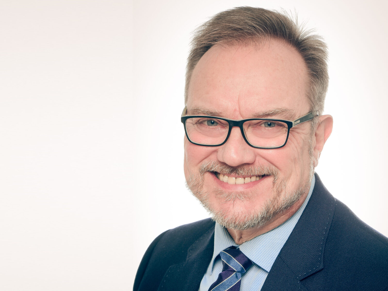 Foto von Prof. Dr. Martin Missong. Er trägt einen blauen Anzug und eine Brille.