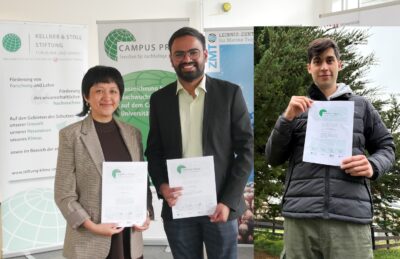 drei lächelnde, mit dem Campus Preis ausgezeichnete Personen mit Urkunden